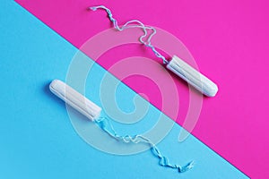 Medical female tampon on a pink blue background. Hygienic white tampon for women