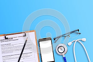 Medical form with smart phone and blue stethoscop on wooden desk photo