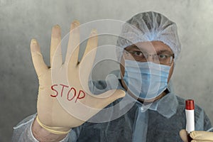 On the medical glove the inscription stop. The concept of preventing the spread of the epidemic and treating the coronavirus.