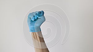 Medical hand with blue glove doing the fist up gesture