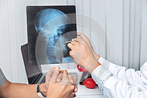 Medical and health care  concept. Doctor explaining x-ray results to patient while sitting at the table in office