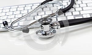 Medical health care concept with stethoscope and computer keyboard in background
