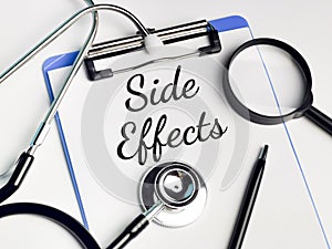 Phrase SIDE EFFECT written on paper clipboard photo