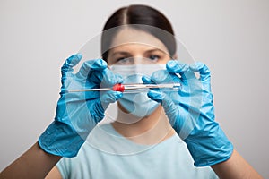 Medical healthcare nurse holding Coronavirus COVID-19 swab test kit, PPE protective mask and gloves, tube for taking OP NP patient