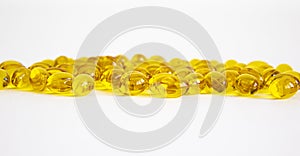 Medical and healthy lifestyle symbol. Yellow vitamins tablets, fish oil, Omega Vitamin E. Pills on a white background. Beautiful