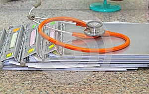 Medical history folder with stethoscope on marble stone desk