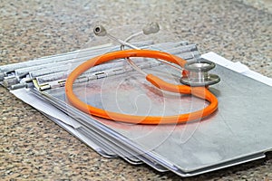 Medical history folder with stethoscope on marble stone desk