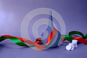 medical holiday background with ribbons, rubber bulb syringe and white tablets