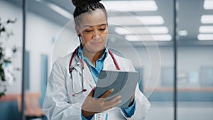 Medical Hospital Portrait: Confident African American Female Medical Doctor Using Digital Tablet Computer