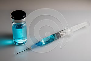 Medical hypodermic syringe in blue colour.