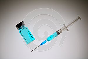 Medical hypodermic syringe in blue colour with needle.