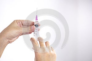 A medical injection syringe in the hand, palm or fingers Vaccination, plastic, medicine Concept of health and treatment