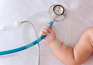 medical instruments stethoscope in hand of newborn baby girl