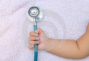 medical instruments stethoscope in hand of newborn baby girl