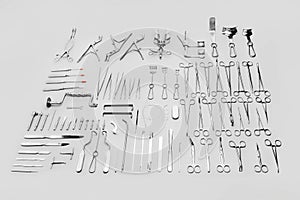 Medical instruments used for surgical operations, laid out on a gray background