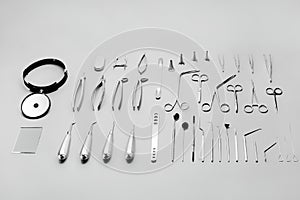 Medical instruments used for surgical operations, laid out on a gray background