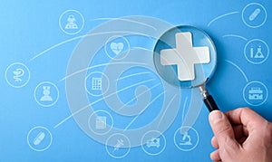 Medical and insurance services with hand with magnifying and icons