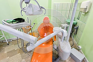 Medical interior, dental office with an orange chair, lamp and equipment. stomatology concept