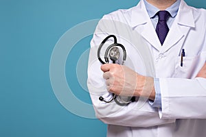 Medical intern or doctor with stethoscope and white clothes isolated on blue wall