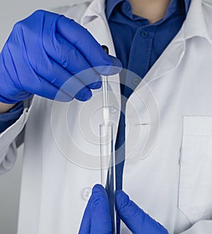 Medical laboratory assistant checks a test tube with sperm. Spermogram. Male fertility test. Semen in a test tube. Reproductive