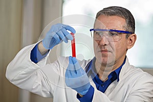 Medical laboratory Scientist Examining Red Liquid In Test Tubes