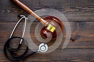 Medical law, health law concept. Gavel and stethoscope on dark wooden backgound top view copy space