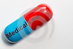 Medical Law stands on a blue and red large medical pill that has been isolated against a white background with space for text