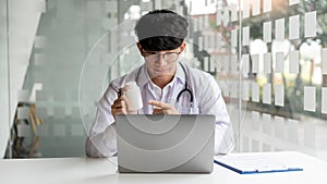 Medical, a male doctor attending online meeting pointing at the pill bottle to explain the pillÃ¢â¬â¢s properties
