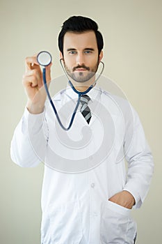 Medical male doctor dressed in uniform showing stethoscope and l