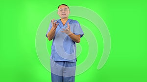 Medical man emotionally looks at something, comments and then disappointedly gives up hands. Green screen