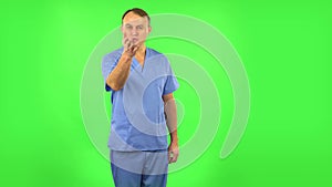 Medical man flirts, blows a kiss and winks. Green screen