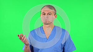 Medical man talking and pointing side hand for something, copy space. Green screen