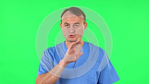 Medical man talks about something then making a hush gesture, secret. Green screen