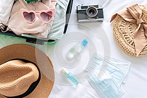 Medical mask, alcohol gel with travel items and luggage prepare for a new normal lifestyle traveling