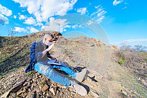 Medical mask as protection against coronavirus. guy in the mountains  from coronavirus. communicates on laptop