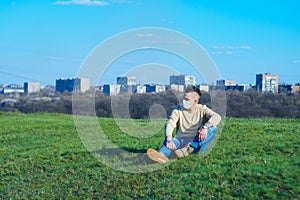 Medical mask as protection against coronavirus. guy sits in a clearing away from the city hiding from the coronavirus