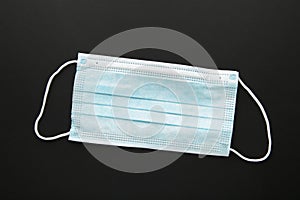 Medical mask on a black background with copy space. Coronavirus