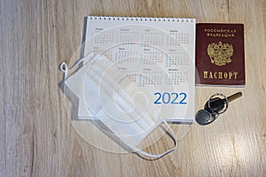 Medical mask and calendar 2022. Keys and passport on the table. Russian passport and calendar