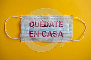 medical mask or cubrebocas with the phrase in Spanish . quedate en casa. photo