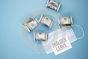 Medical mask with dollars and the words paid sick leave on a blue background