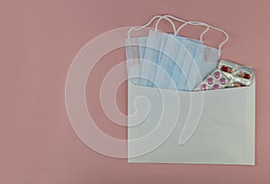 Medical mask in an envelope on a pink background,