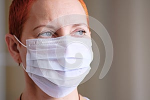 Medical mask on the girl`s face. Personal protective equipment. The concept of preventing the spread of the virus during
