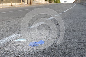 Medical mask and gloves thrown in the street. New concept of normality. Coronavirus