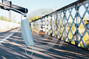 Medical mask on the handlebars of a motorcycle