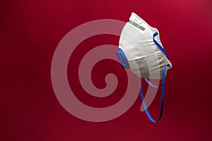 Medical mask for healthcare workers isolated on red background