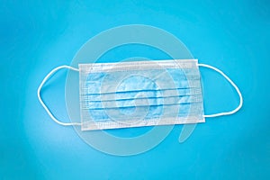 medical mask lies on a blue background, hygiene products protection from covid