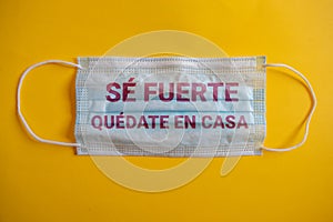 medical mask with the phrase in Spanish se fuerte. quedate en casa. photo