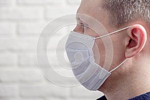 Medical mask, protection against coronavirus and other viruses on the white brick wall background