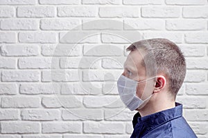 Medical mask, protection against coronavirus and other viruses on the white brick wall background