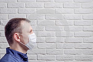 Medical mask, protection against coronavirus and other viruses on the white brick wall background